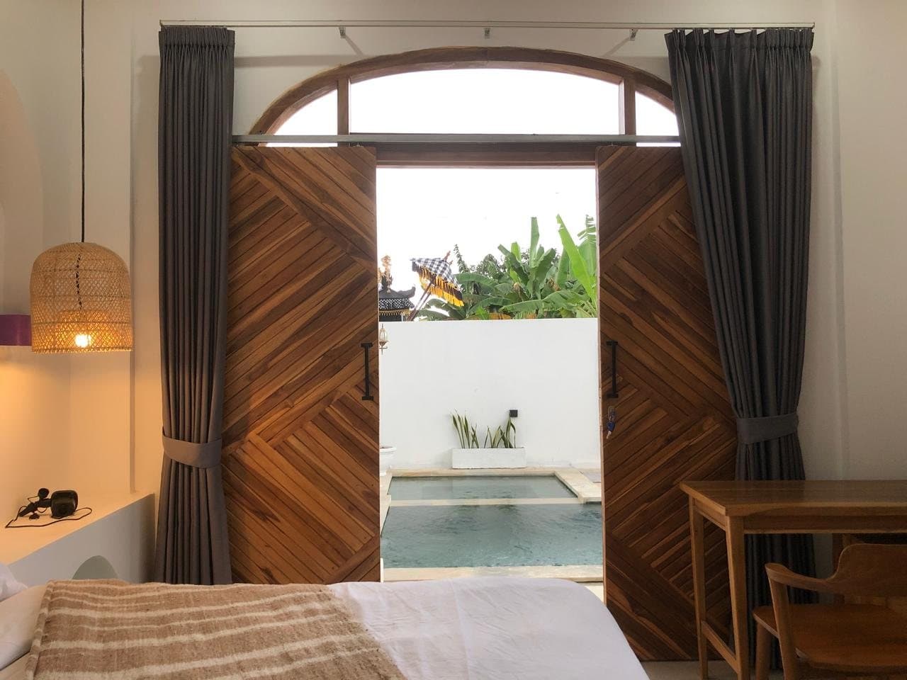 Bedroom with teak doors open to the pool
