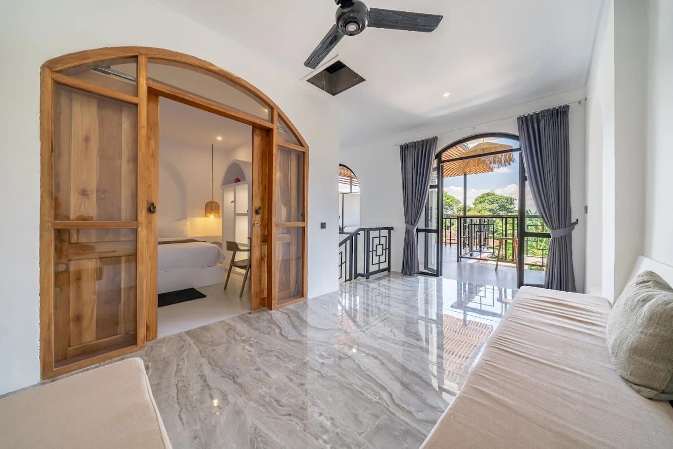 Arched teak doors and marble landing leading to a balcony