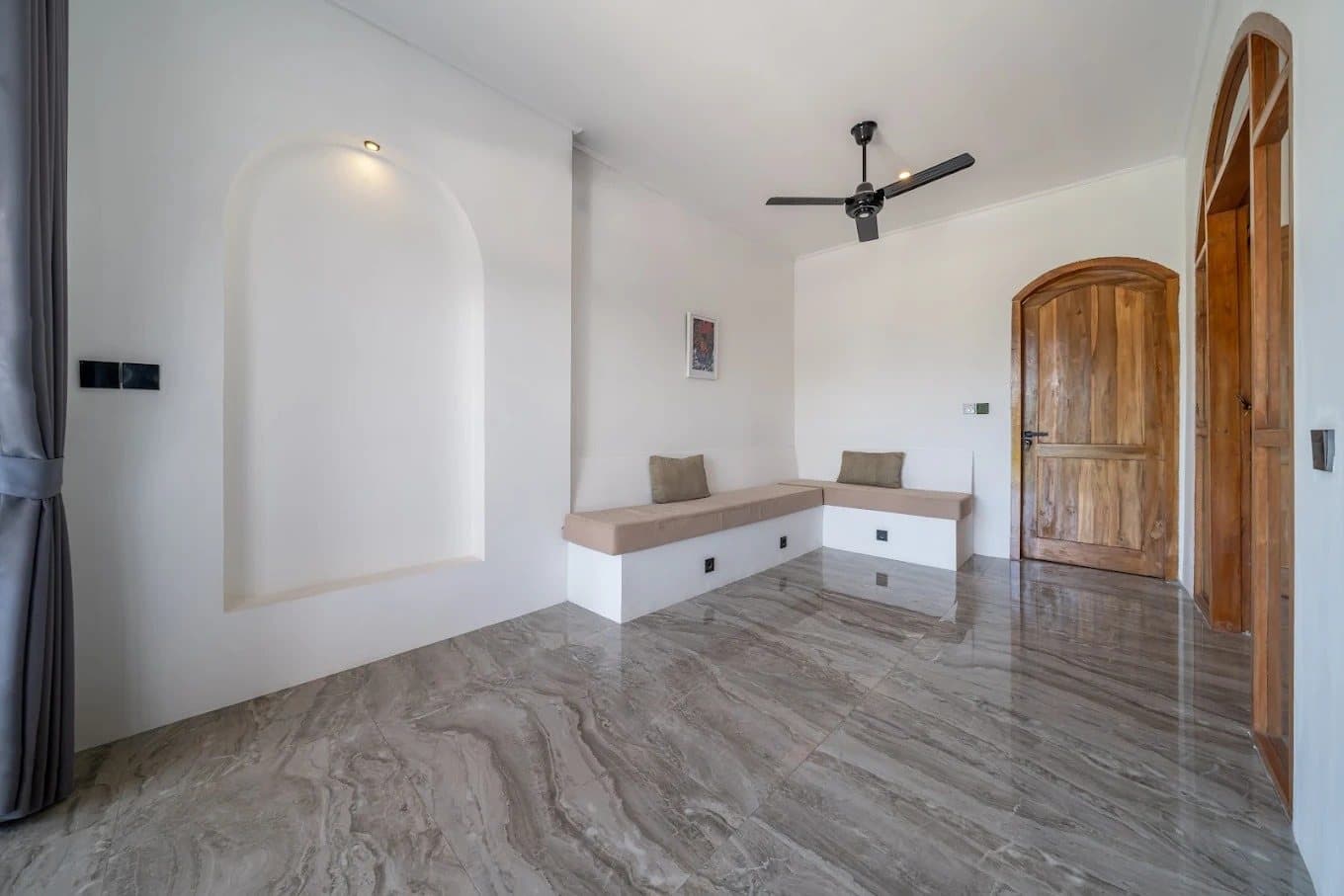 Upstairs lounge with marble floor, built-in seating and arched niche