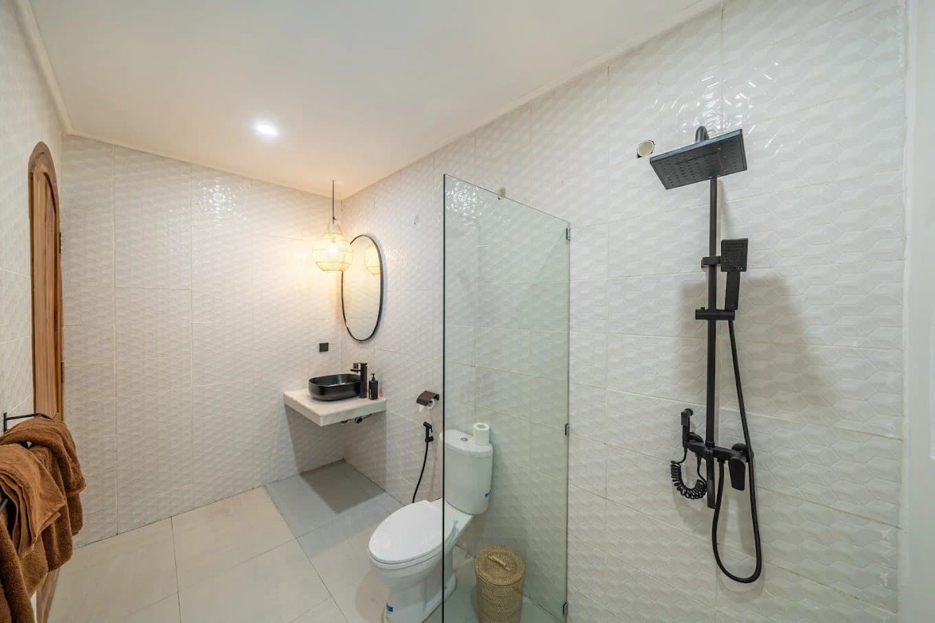 White en-suite bathroom with glass rain shower