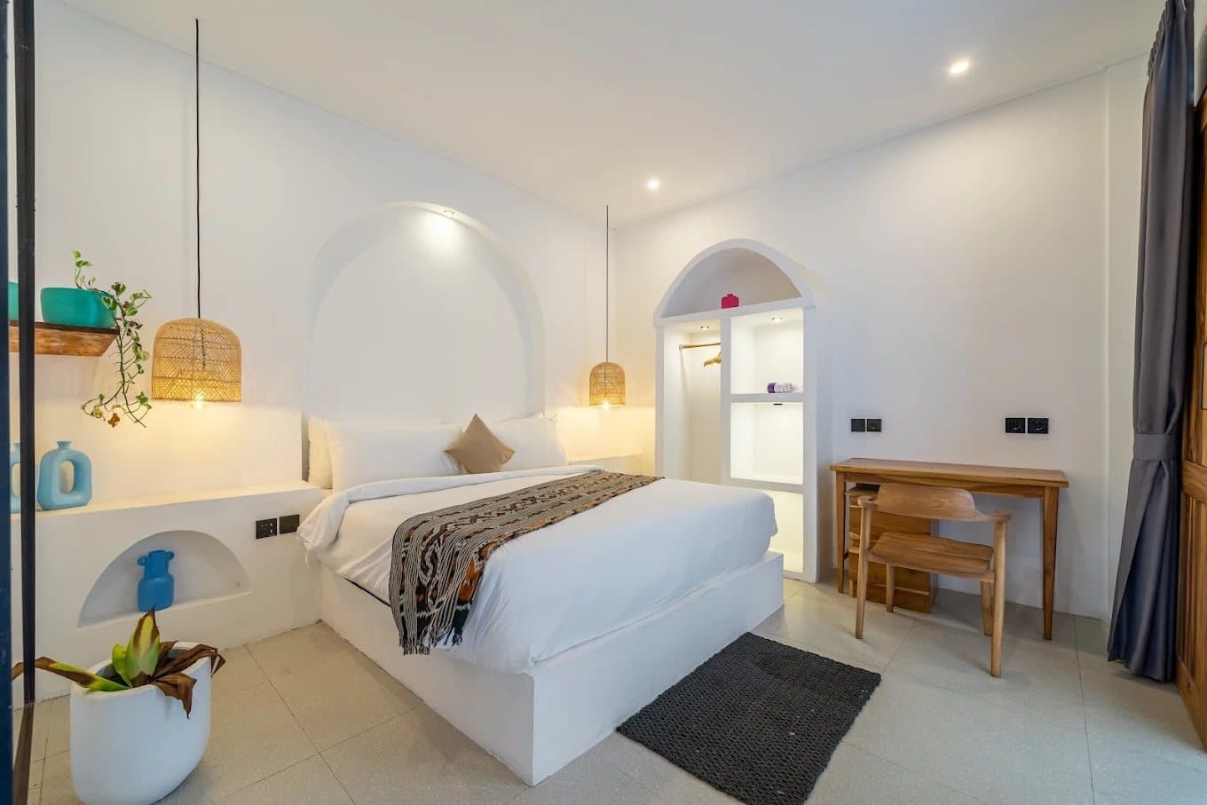Bedroom with desk, plants and an arched alcove