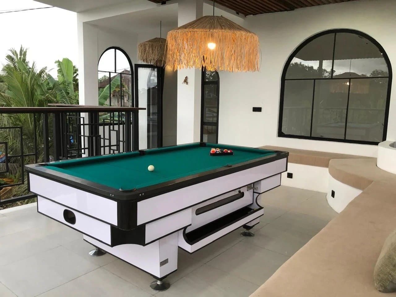 Pool table on the deck under a woven pendant